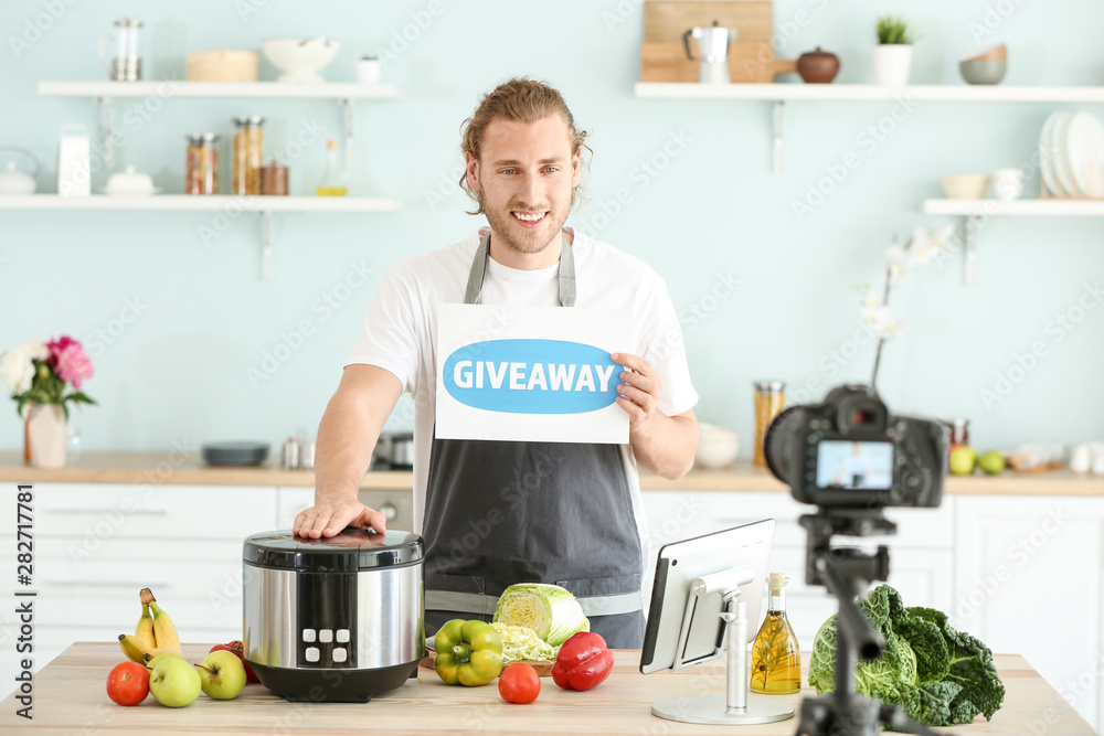 Food blogger announcing prize drawing while recording video in kitchen Food blogger announcing prize drawing while recording video in kitchen