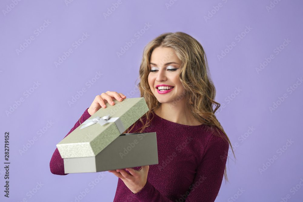 Beautiful young woman with gift box on color background Beautiful young woman with gift box on color background