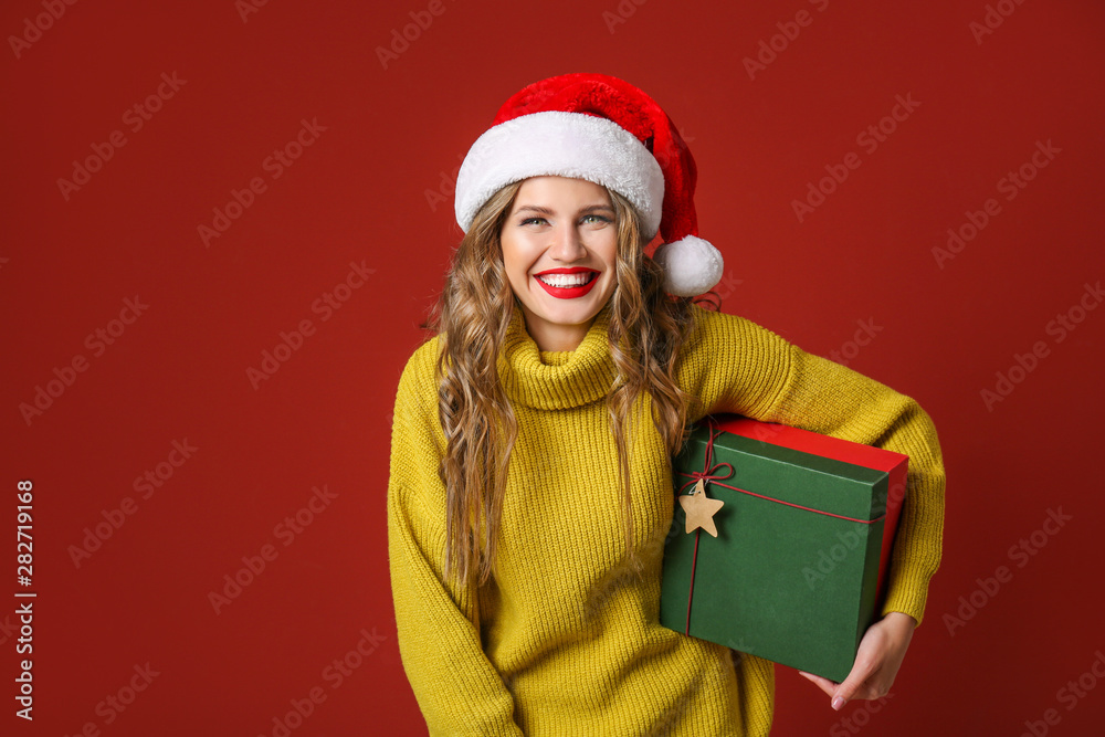 Beautiful young woman with Christmas gift on color background Beautiful young woman with Christmas gift on color background