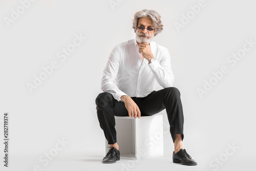 Fashionable senior man on light background photo