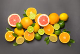 Different citrus fruits on dark background