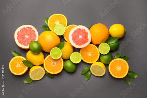 Different citrus fruits on dark background