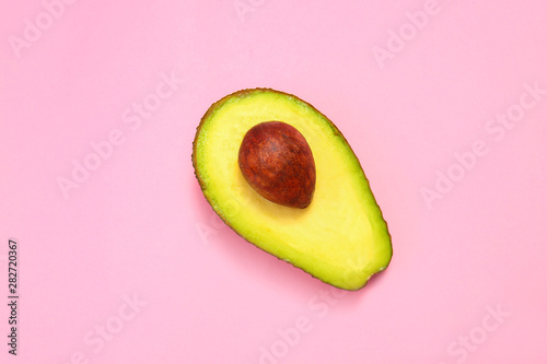 Half of ripe avocado on color background