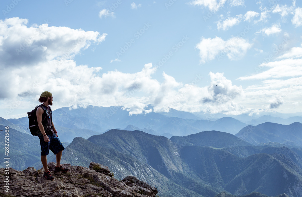 boy alone on a mountain looking at the horizon