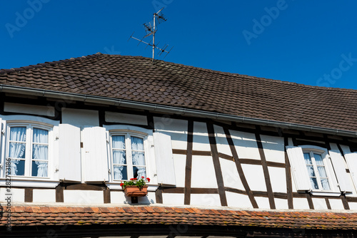 white half timbered house with shutters and orange roof tiles. Hunspach, France photo