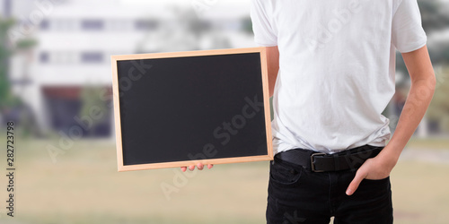 young man holding blackboard with space for text