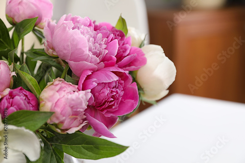 Fototapeta Naklejka Na Ścianę i Meble -  Bouquet of beautiful peonies on table in room, closeup. Space for text