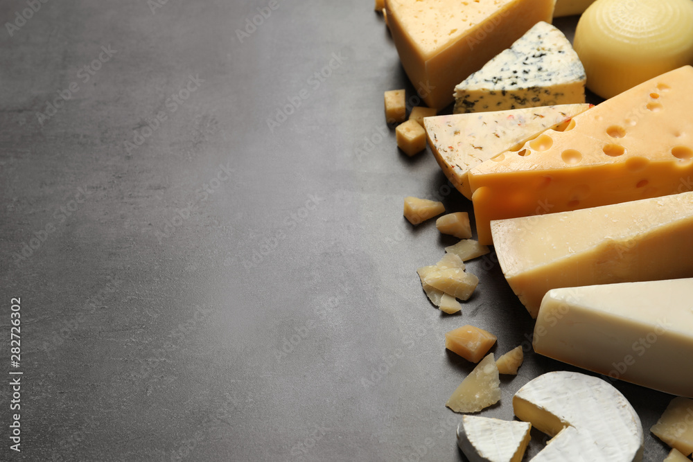 Fototapeta premium Different delicious cheeses on grey table, space for text