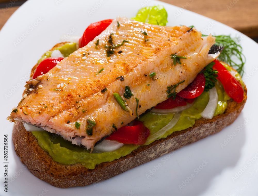 Slice of bread with roasted trout fillet