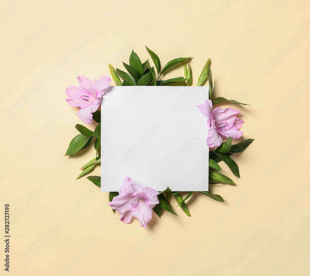 Beautiful gladiolus flowers and blank card on yellow background, flat lay. Space for text