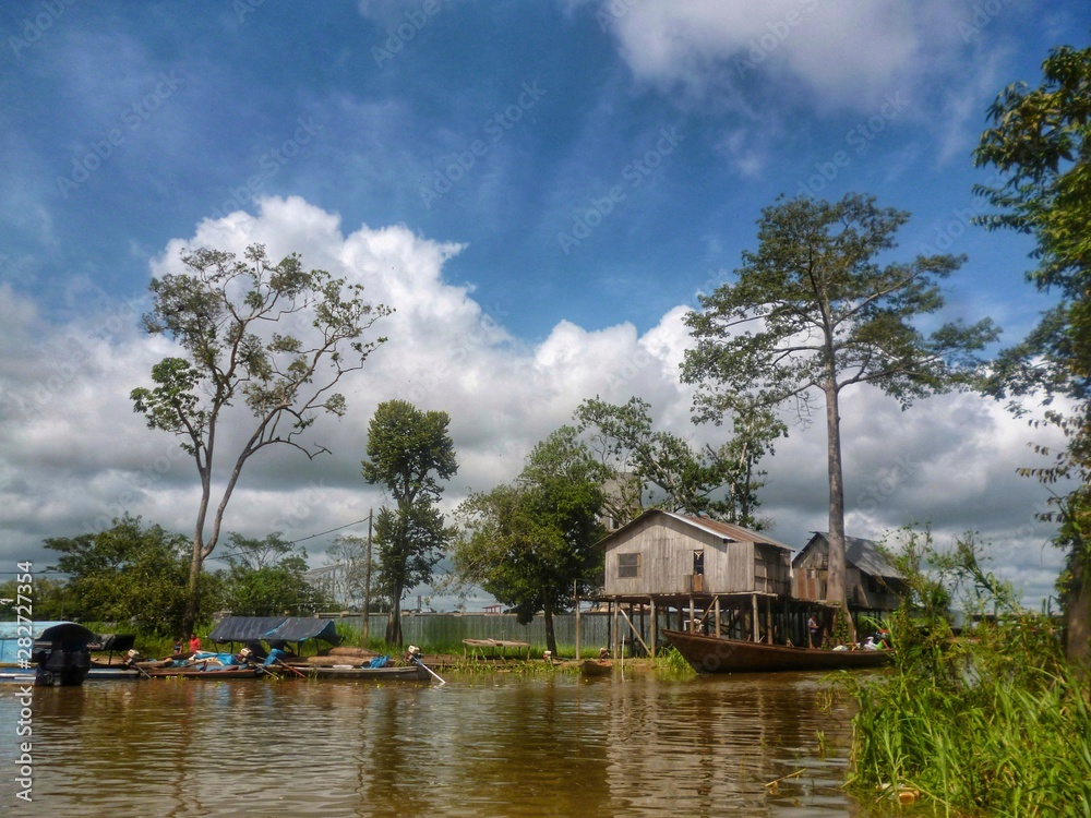 Fototapeta premium Balsas y casas en el río Ucayali un día soleado Peru