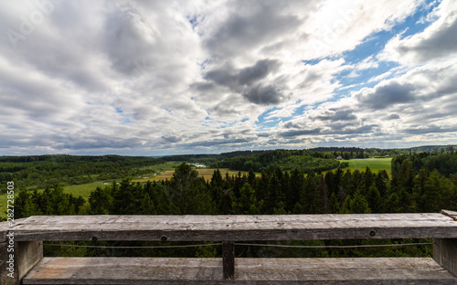 Panorama photo of finnish countryside with dramatic clouds. Bright summer weather with vibrant colors.