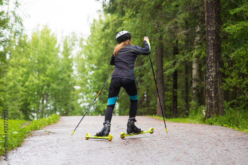 Woman cross-country skiing with roller ski in park