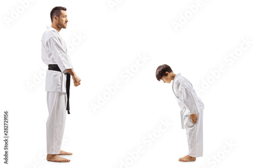 Boy in karate kimono bowing to instructor