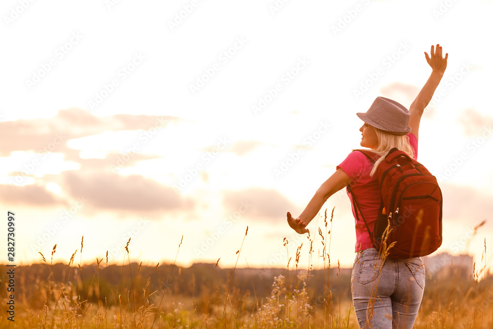 Hipster young girl with backpack enjoying sunset. Tourist traveler on background. Hipster young girl with backpack enjoying sunset. Tourist traveler on background.
