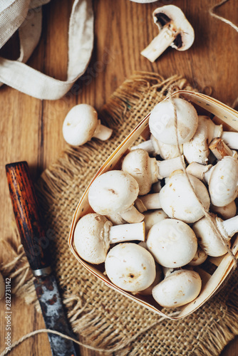 champignons  mushrooms in a wooden eco basket on a wooden background