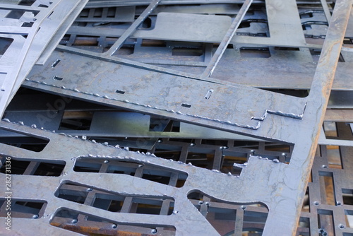 Perforated metal sheets after laser cutting lie on each other. Metalworking waste prepared for recycling.