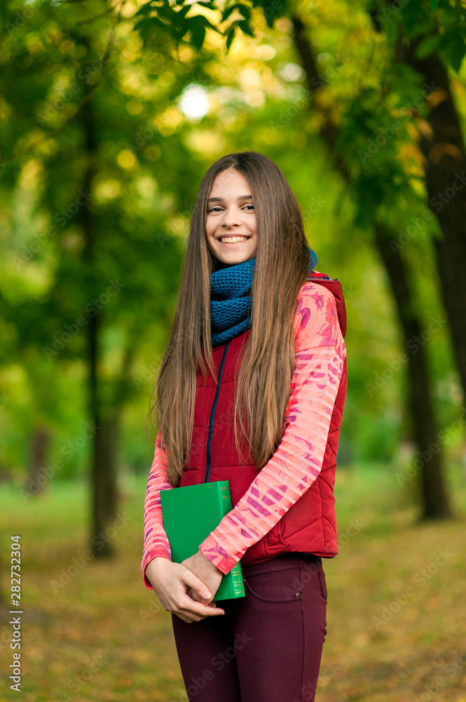 Young romantic girl reading a book sitting on the grass Young romantic girl reading a book sitting on the grass