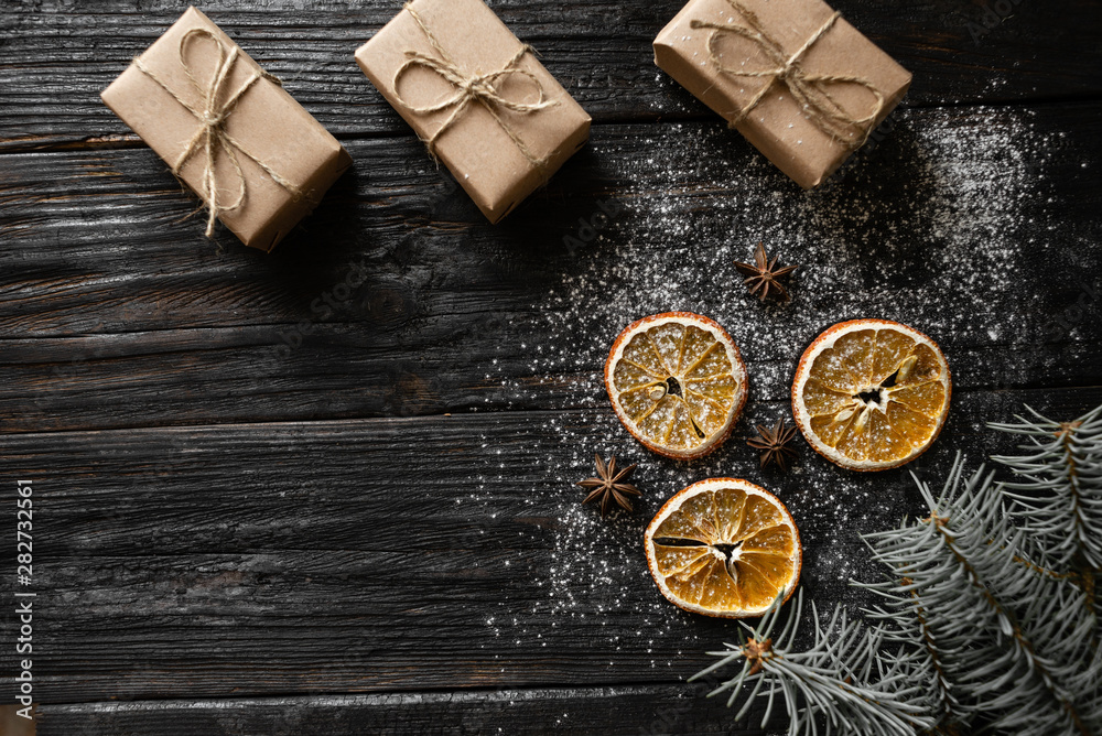 Christmas background with place for your text. Orange slices and gifts lie on a wooden table Christmas background with place for your text. Orange slices and gifts lie on a wooden table