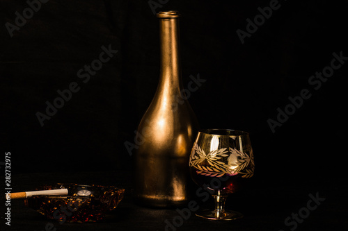 bottle and wine glass photographed on black background