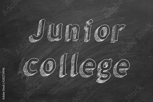 Hand drawing "Junior college" on black chalkboard.