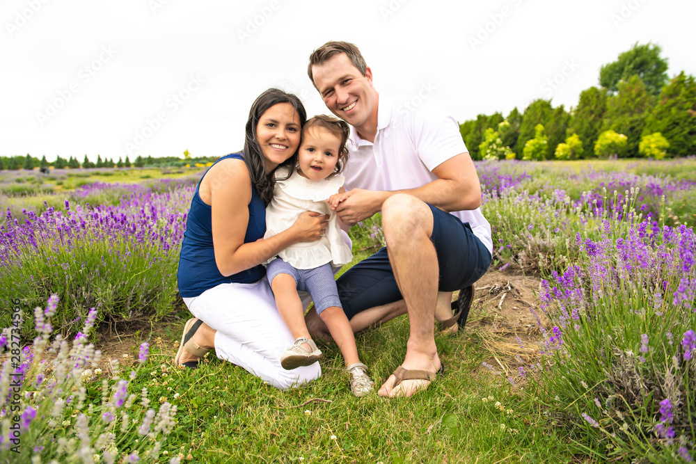 Happy family mother, father and daughter having fun in lavender field Happy family mother, father and daughter having fun in lavender field