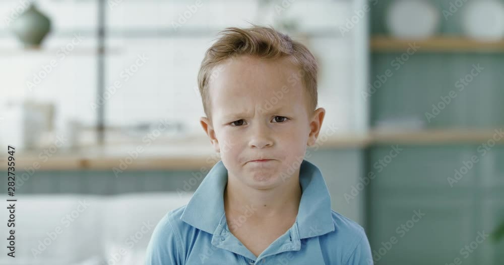 FIXED Portrait of little cute unhappy Caucasian kid boy, looking into camera. 60 FPS Slow Motion, 4K RAW graded footage