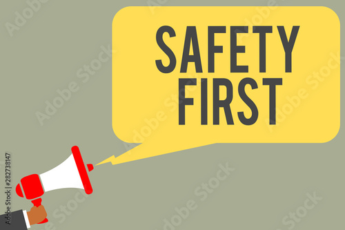 Conceptual hand writing showing Safety First. Business photo text Avoid any unnecessary risk Live Safely Be Careful Pay attention Man holding megaphone loudspeaker speech bubble message speaking photo