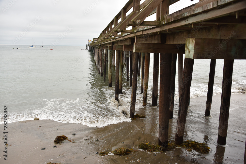 Pier in California with waves and sand