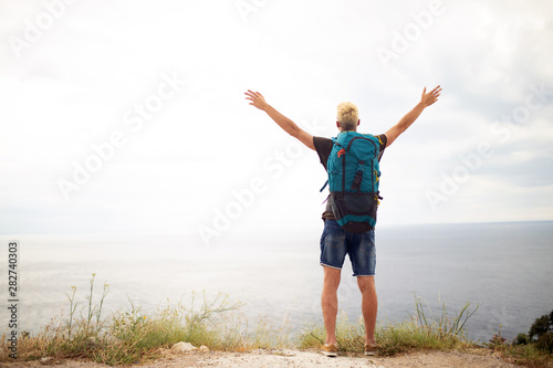 Happy man on mountain enjoying landscape. Travel  vacation  adventure  freedom concept