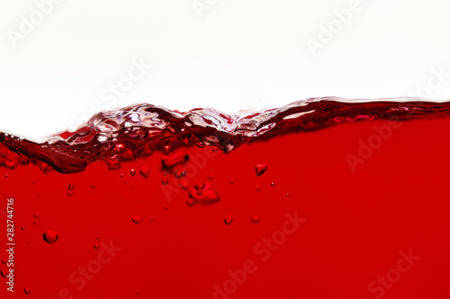 red bright liquid wave with bubbles isolated on white photo
