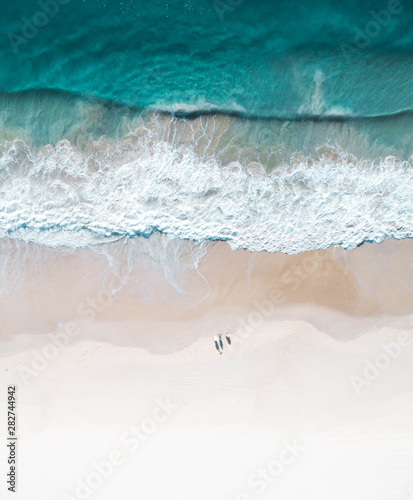Beautiful beach and water at sunrise with people standing in front of wave and on white sand on the Gold Coast. Queensland New South Wales Brisbane Byron Bay Sunshine Coast Noosa Bondi Manly photo