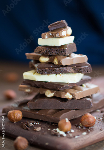 Foto The different grades of chocolate put by the hill on a wooden board, with a filbert can on a rust metal surface