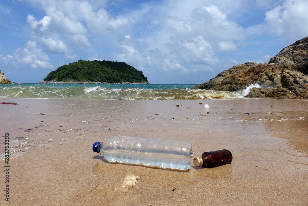 Pollution on beach. Plastic bottle and glass bottle on the beach. World environment day, environment protection concepts. Selective focus, with copy space Pollution on beach. Plastic bottle and glass bottle on the beach. World environment day, environment protection concepts. Selective focus, with copy space