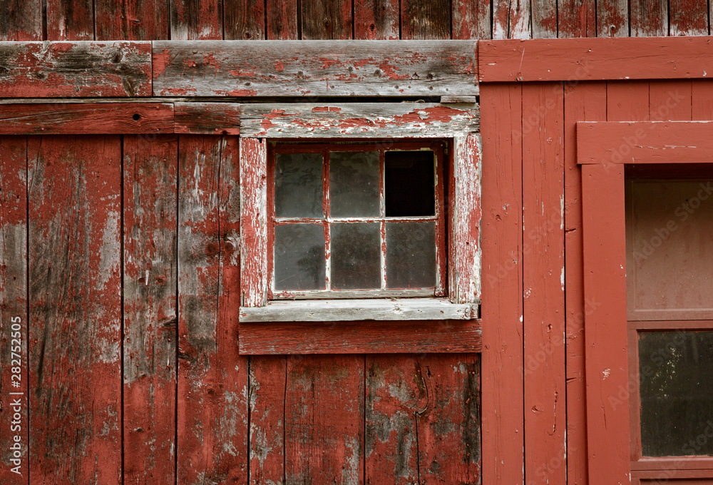 Weathered red paint and broken windows are a common site on barns in Vermont Weathered red paint and broken windows are a common site on barns in Vermont