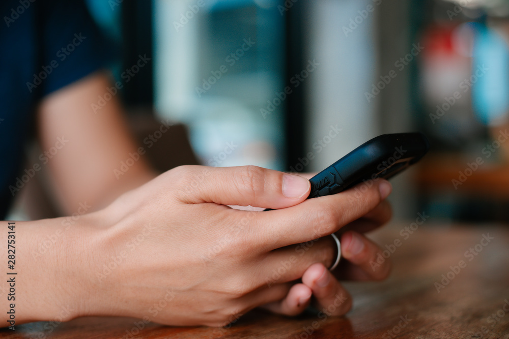 woman's hands are using a smartphone at home.