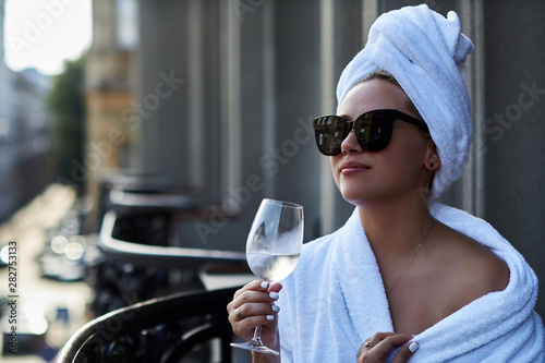 Woman enjoying a glass of champagne and view of the old town on the terrace photo