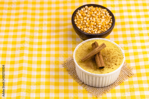 Brazilian sweet corn cream, Dessert, canjica or Jimbelê, dessert cured corn corn mousse with cinnamon on a wood background. Copy space