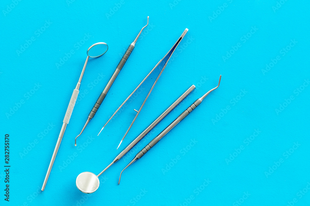 stomatologist instruments on blue doctor's office desk background top view