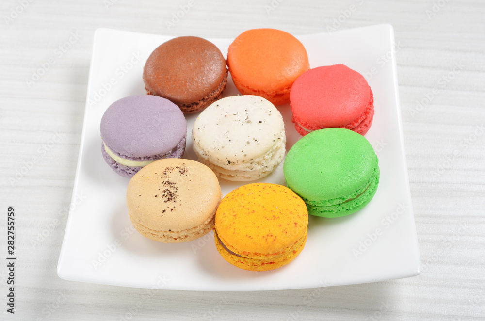 Obraz premium Colorful french macarons on white plate