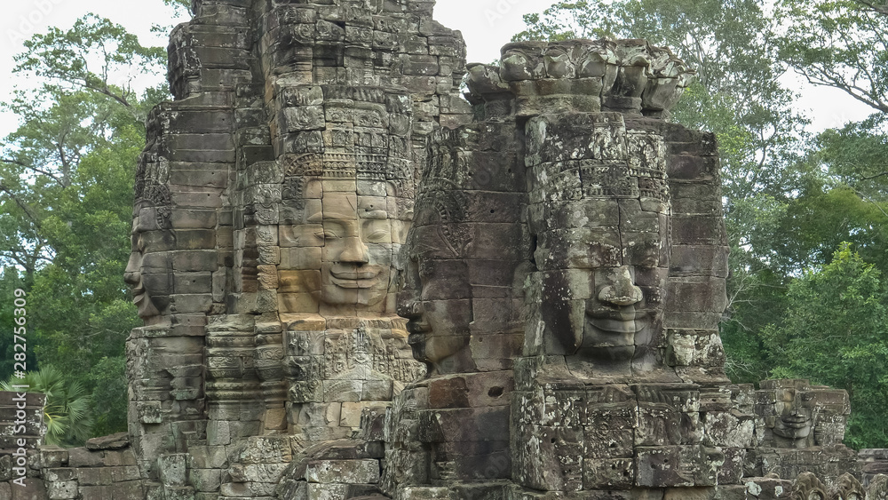 four large carved stone faces at bayon temple four large carved stone faces at bayon temple