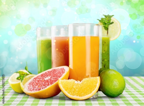 Tasty fruits and juice with vitamins on background