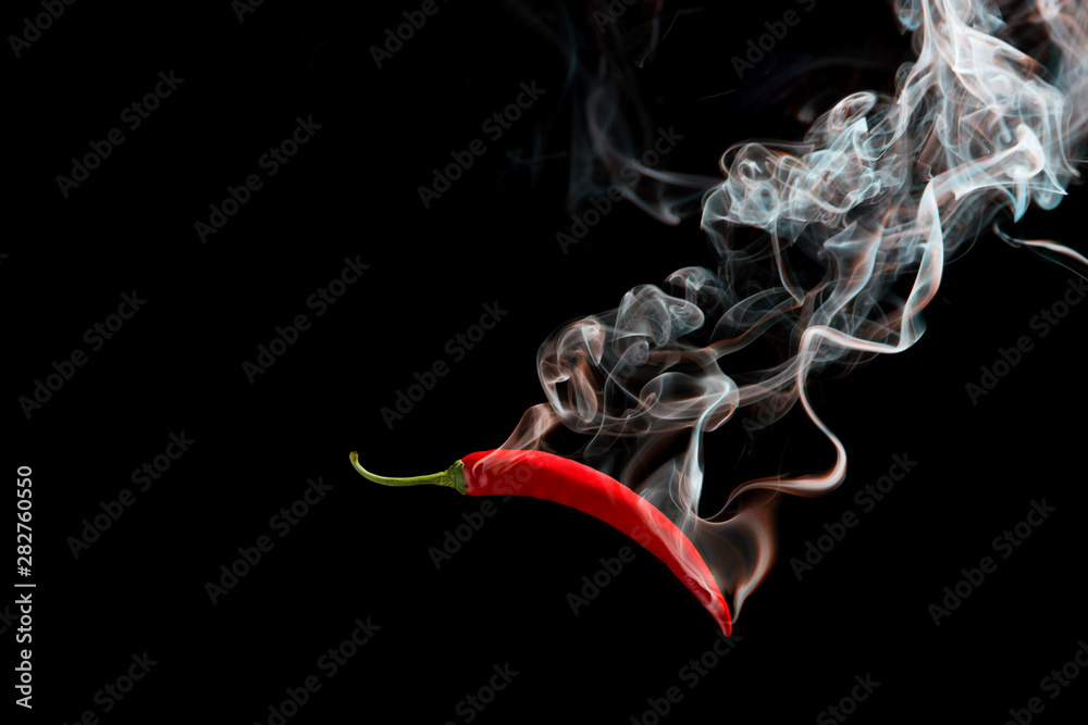 Fototapeta Czerwone chili z dymem na czarnym tle, pojęcie pikantne