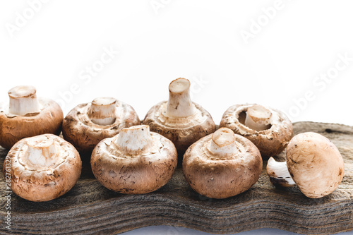 Mushrooms on White Background. Fresh Organic Crimini Mushrooms on a Wooden Board Close Up on White Background