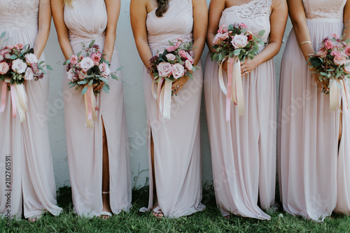 bridesmaids holding wedding bouquets, pink bridesmaids dresses, detail shot, copy space photo