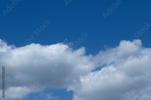 Background of blue sky with white fluffy clouds. Cropped shot  horizontal  outdoors  nobody. Concept of nature and ecology.