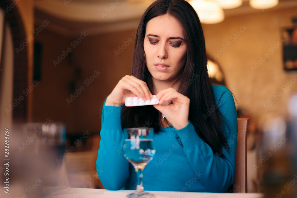 Woman Taking Her Pills in a Restaurant Woman Taking Her Pills in a Restaurant