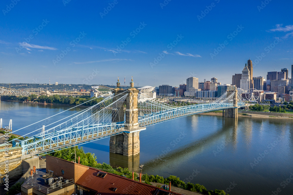 Naklejka premium Panoramic view of Cincinnati downtown with the historic Roebling suspension bridge over the Ohio river