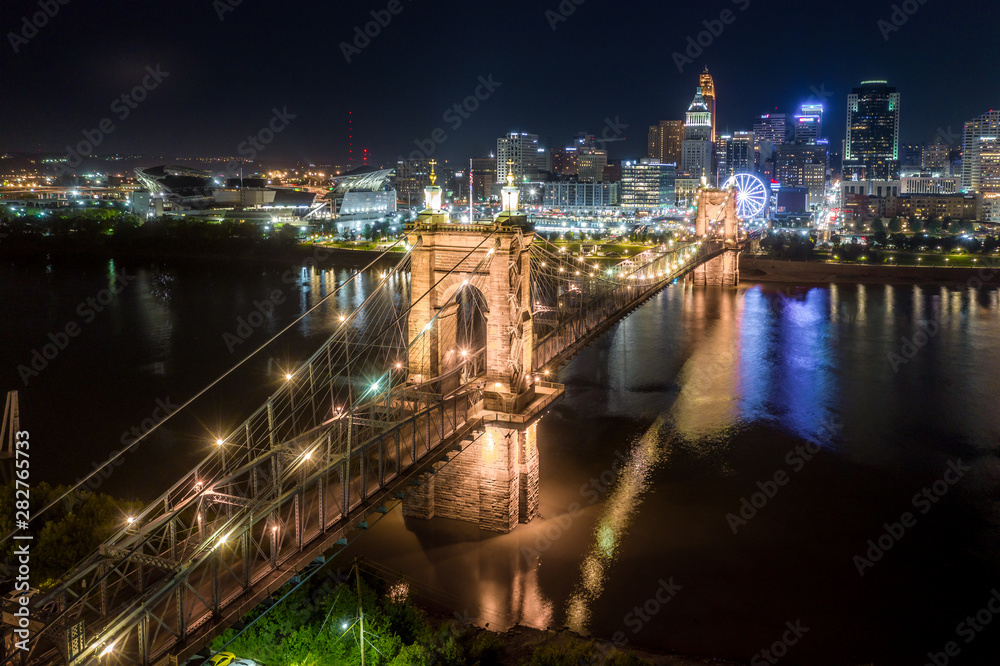 Aerial night view of the Roebling bridge in Cincinnati Ohio with a Ferris wheel in the background
