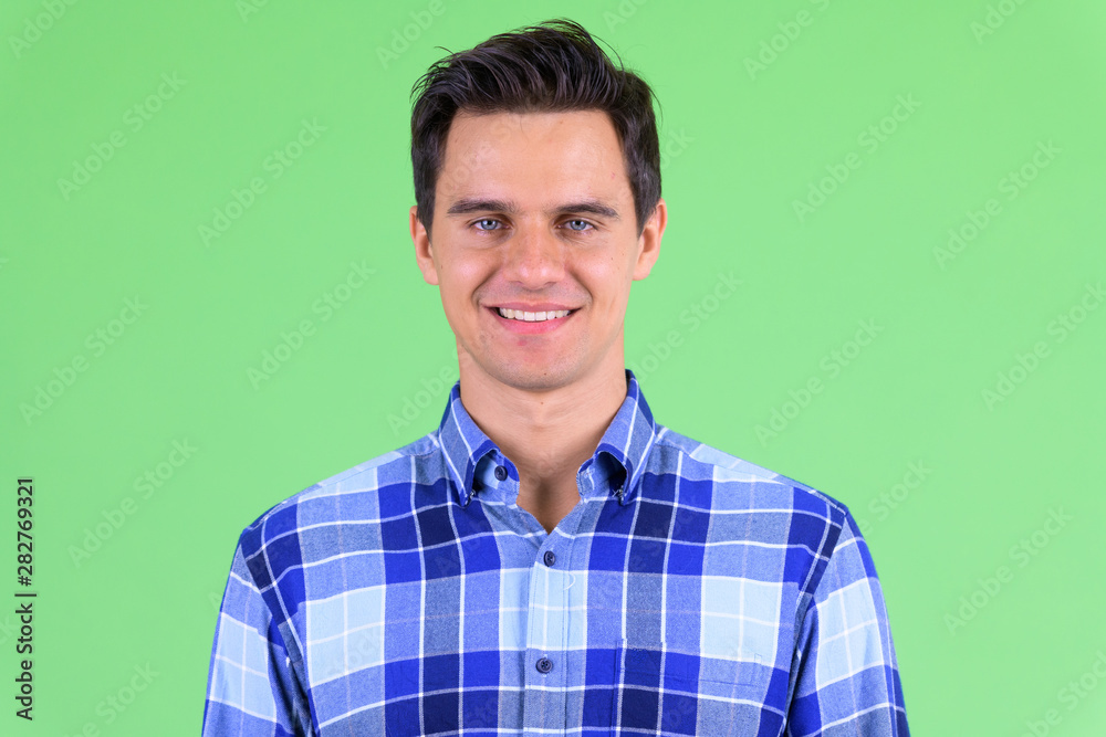 Face of happy young handsome hipster man smiling